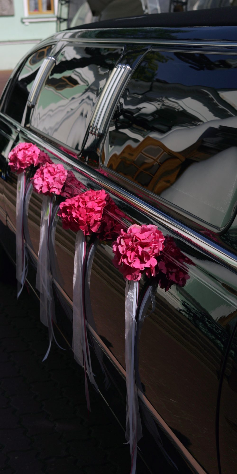Black wedding limousine with flowers on side